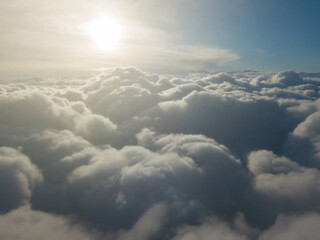 Fototapeta premium Aerial high flight above the clouds at sunrise.