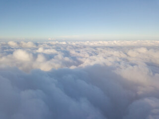 Fototapeta na wymiar Aerial high flight above the clouds at sunrise.