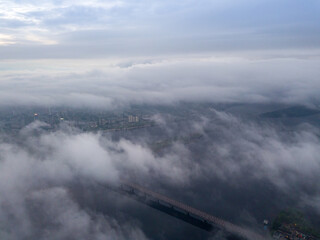 High view of the Dnieper River in Kiev. Aerial high flight above the clouds.