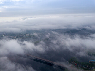 High view of the Dnieper River in Kiev. Aerial high flight above the clouds.