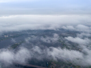 High view of the Dnieper River in Kiev. Aerial high flight above the clouds.