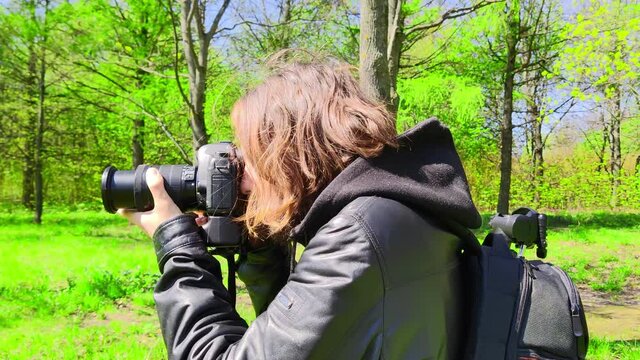 Photographer and paparazzi secretly takes photos in the park. Job of selling light, memories and life