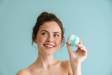 Half-naked brunette woman smiling while posing bath bomb