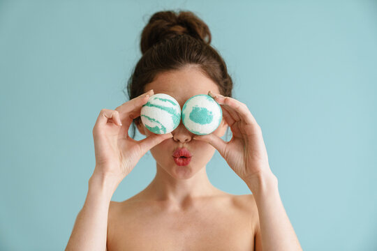 Half-naked brunette woman making with bath bombs