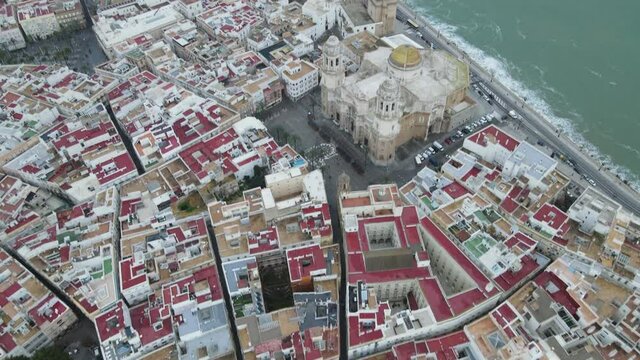 Aerial view of Cadiz and its red rooftops and churches and the La Pepa Bridge in the background.
