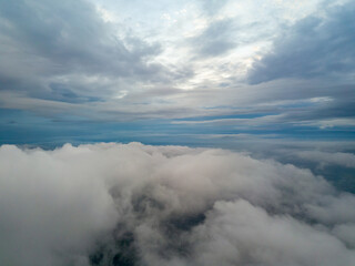 Fototapeta na wymiar Aerial high flight above the clouds. The rays of the rising sun break through the clouds.