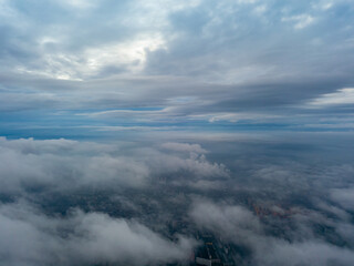 Plakat City under the clouds at dawn. Aerial high drone view.