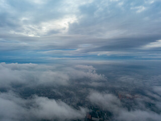 Fototapeta na wymiar City under the clouds at dawn. Aerial high drone view.