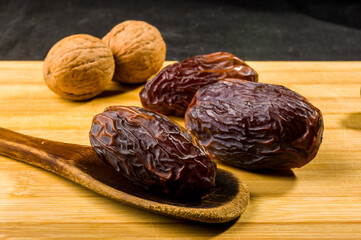 Big luxury dried date fruit on the wooden board, kurma ramadan kareem concept, close up.