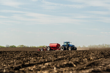 Fototapeta premium A tractor cultivating field at spring morning.