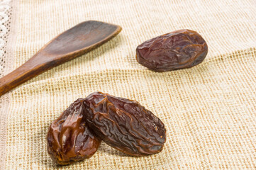 Big luxury dried date fruit on a linen napkin, kurma ramadan kareem concept, close up.