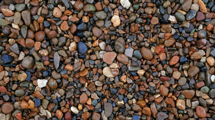 Sea or river multicolored pebbles. Natural texture of beach pebbles. Weathering and erosion of rocks. Drainage systems from small pebbles. Garden drainage for plants and trees. Blue stones for roads.