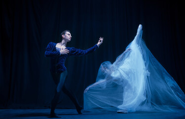 Graceful balerina in image of ghost bride with patner in art ballet performance isolated over dark background. © Lustre Art Group 