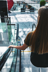 Young woman standing at the escalator in subway