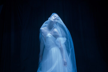 Despair. Young graceful balerina in image of ghost bride in art performance isolated on dark...
