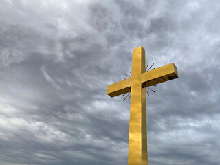 Golden cross on cloudy sky background