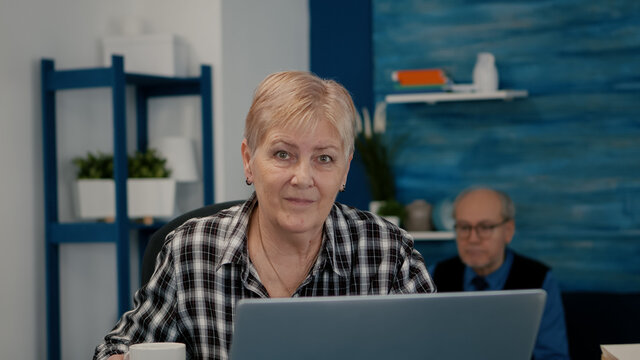 POV Of Elderly Aged Woman Waving During A Video Conference With Business Partners Working From Home. Senior Person Using Internet Online Chat Technology Webcam Making Virtual Meeting Call Connection