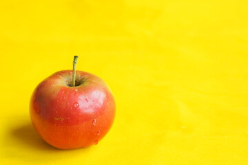 pple ripe red isolated, close-up, on a yellow background with a place for the inscription. High quality photo