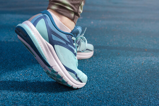 legs of a woman in blue sneakers  close up