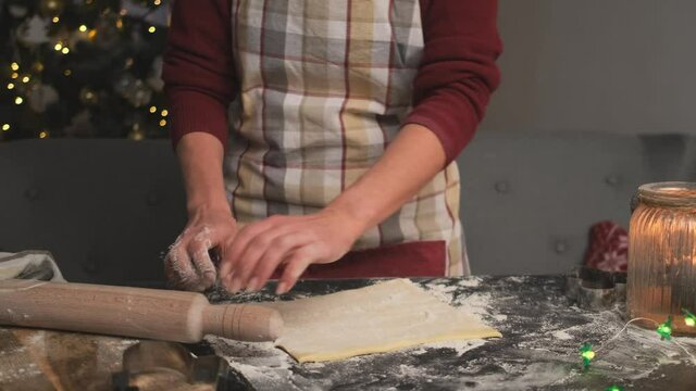 Woman rolling dough for homemade gingerbread before christmas