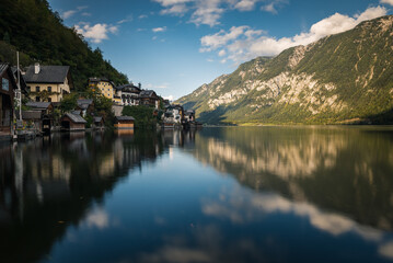 Reflections of village houses and mountain landscapes in a crystal clear lake in the town of Hallstatt in Austria.
