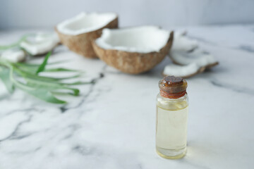slice of fresh coconut and bottle of oil on a table 