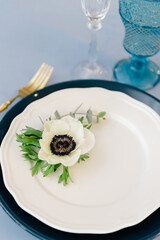 Festive spring table setting with anemone and golden cutlery
