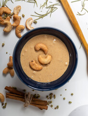Jar of cashew butter with cashew nuts on the white  background. Top view.