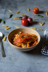 A cooked bowl of pasta with tomato sauce on a background. Close up.
