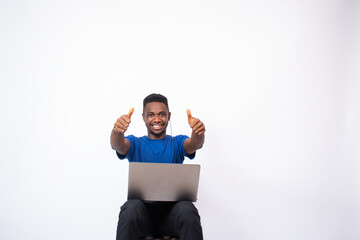 young african man with a laptop computer on his lap, doing the thumbs up gesture