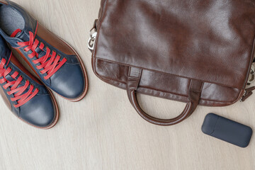 Fototapeta premium Top view of men set shoes, bag on wooden background