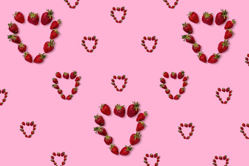 Pattern of strawberries in the shape of hearts on a pink background