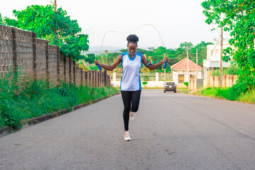young black woman doing jump ropes outside - obrazy, fototapety, plakaty