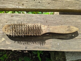 old wire brush on wooden background top view
