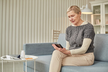 Sick woman during a video call with a doctor. Side view of a patient in quarantine during a conference call with his doctor.