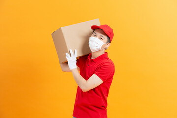 Home delivery, online order. Male courier in a medical mask and  gloves with a parcel in his hands