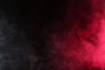 Artificial smoke in white-red light on a black background