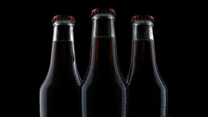 three bottles with a drink on a dark background