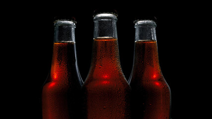 three bottles with a drink on a dark background