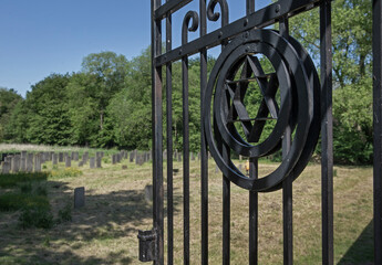 Gate at Abandoned Jewish cemetry with old gravestones. Thombstones. Flevopark Amsterdam Netherlands. Ashkenazi Jews. David star.