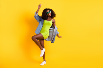 Fototapeta na wymiar Full length body size view of attractive cheerful slender girl dancing having fun isolated over bright yellow color background