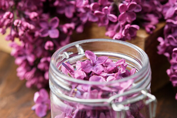 Obraz na płótnie Canvas Lilac flowers in a jar, bunch of Syringa flowers. The preparation of infusion, aromatic sugar or jam from Lilac flowers at home.
