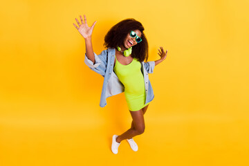 Full length body size photo of girl in sunglass spending free time at party wearing headphones isolated vivid yellow color background