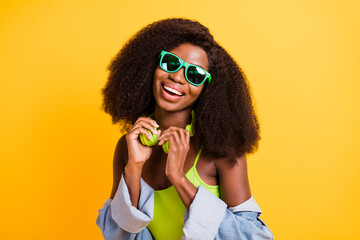 Photo portrait of young woman laughing wearing sunglass curly hairstyle isolated vibrant yellow color background