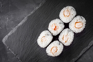 appetizing sushi shrimp maki roll on a black stone plate