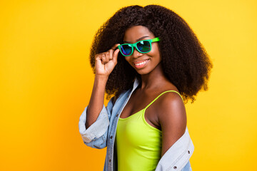 Photo portrait of young woman smiling wearing sunglass stylish clothes curly hairstyle isolated vivid yellow color background