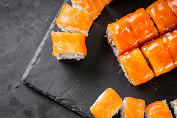 appetizing set of sushi roll on a black stone plate