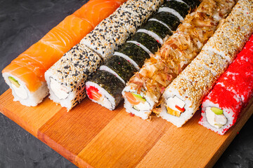 appetizing set of sushi roll on a black stone plate