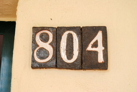 Dark Coloured Ceramic Number Tiles 804 on Textured Interior Wall  