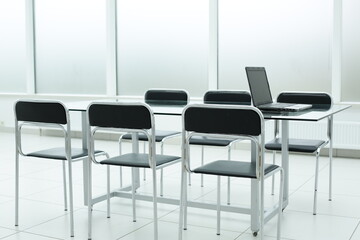 Laptop on glass table in spacious office space